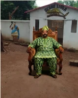 Fils DAH GBEWENONDO GLELE devant le temple traditionnel Segbo Lissa pour la consultation du Fâ